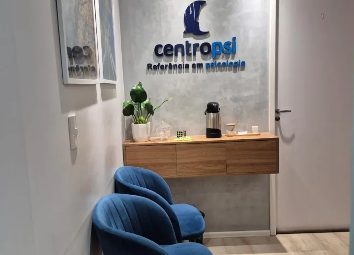 Recepção da CentroPsi com poltronas azuis e identidade visual da clínica